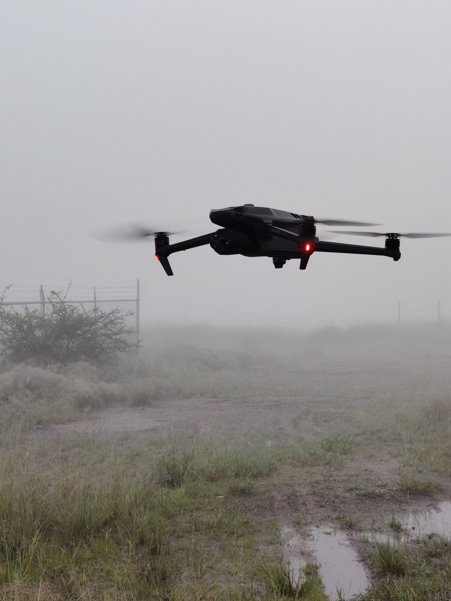 Survey drone flying low over a field site in the fog